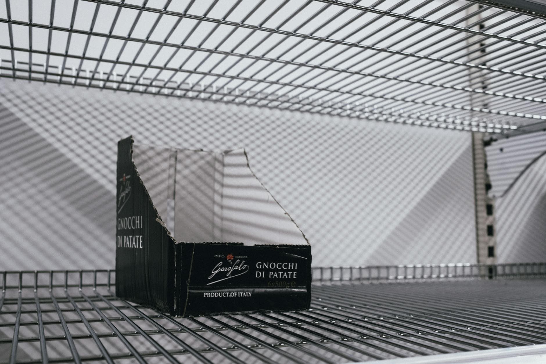 Pharmaceutical warehouse worker checking expiration dates on inventory bins with date-coded labels