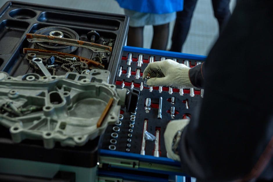Mechanic organizing engine parts and maintenance tools on a workshop bench