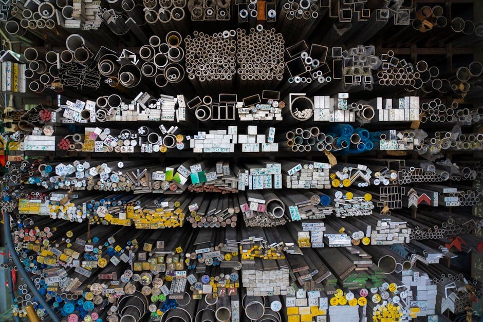 Diverse collection of stacked metallic pipes and rods showing product variety in a warehouse